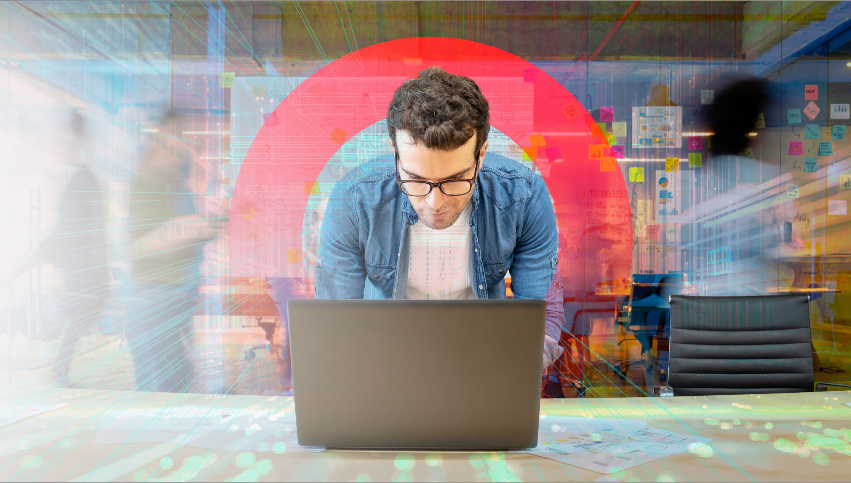 Person working on a laptop in an office setting surrounded by engineering graphs and data