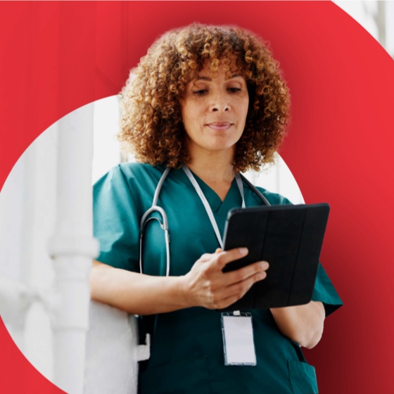 healthcare worker in scrubs using a tablet