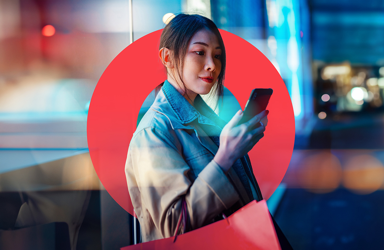 Woman looking at her phone on a busy street