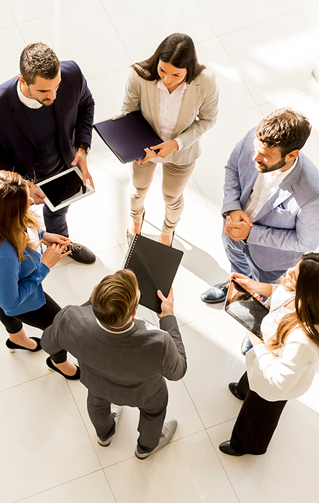 business meeting of three women and three guys holding laptops or notebooks